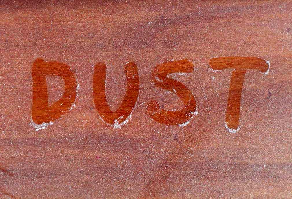 Dust written on dusty table
